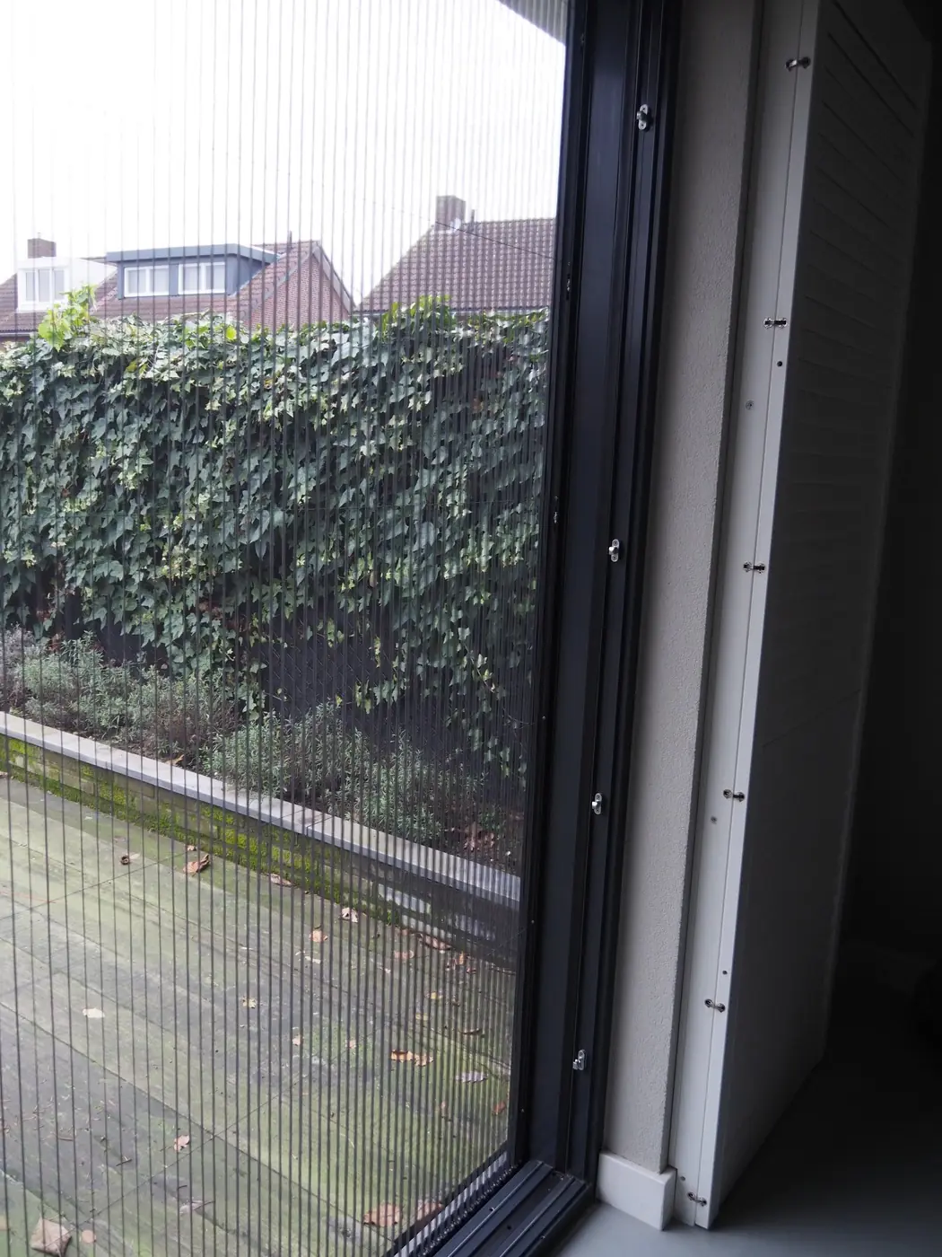 Plissé hordeur half open bij een tuindeur