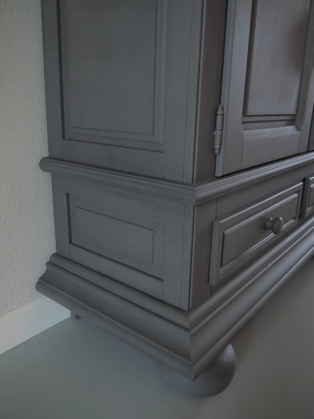 Detail van het lijstwerk van een in krijtverf geschilderde linnenkast
