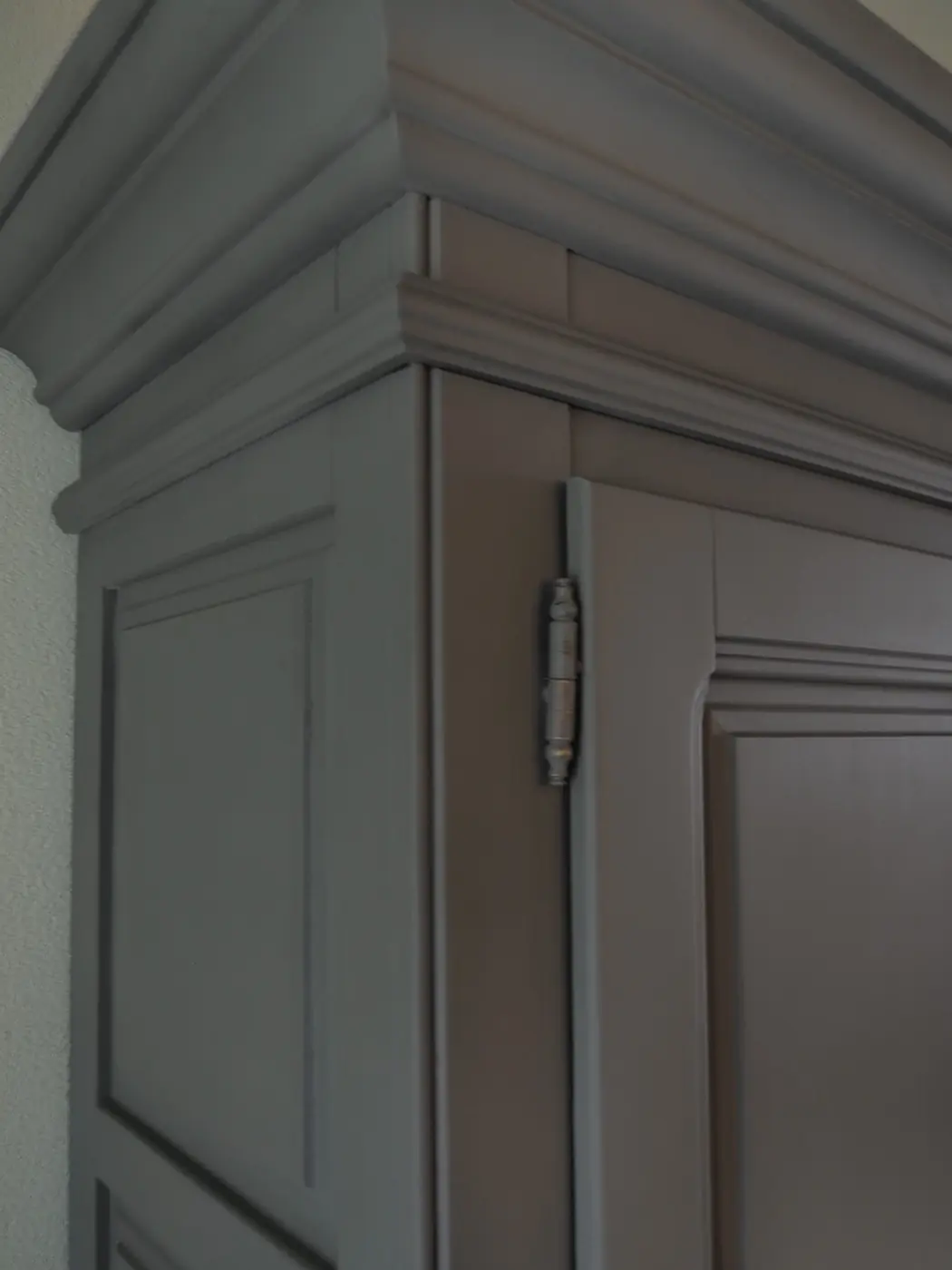 Detail van de kroonlijst van een antracietgrijs geschilderde kast