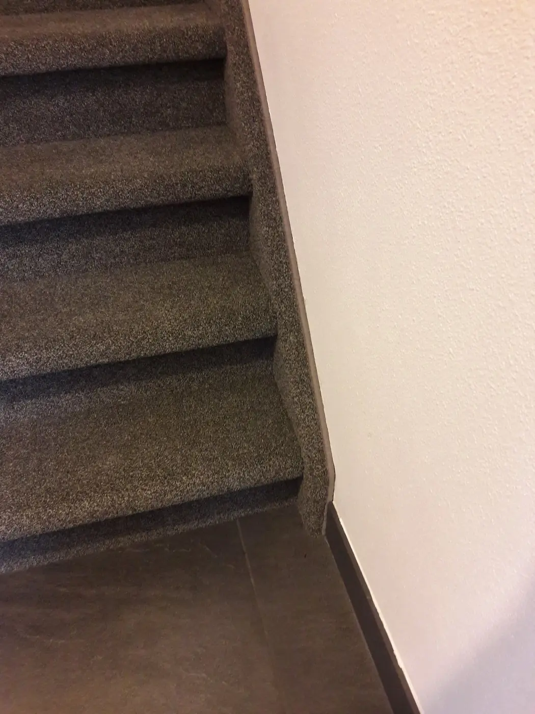 Detail van tapijt strak om de neus van de traptreden